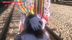 Payaso casi es atropellado por un tren mientras le mete la cabeza